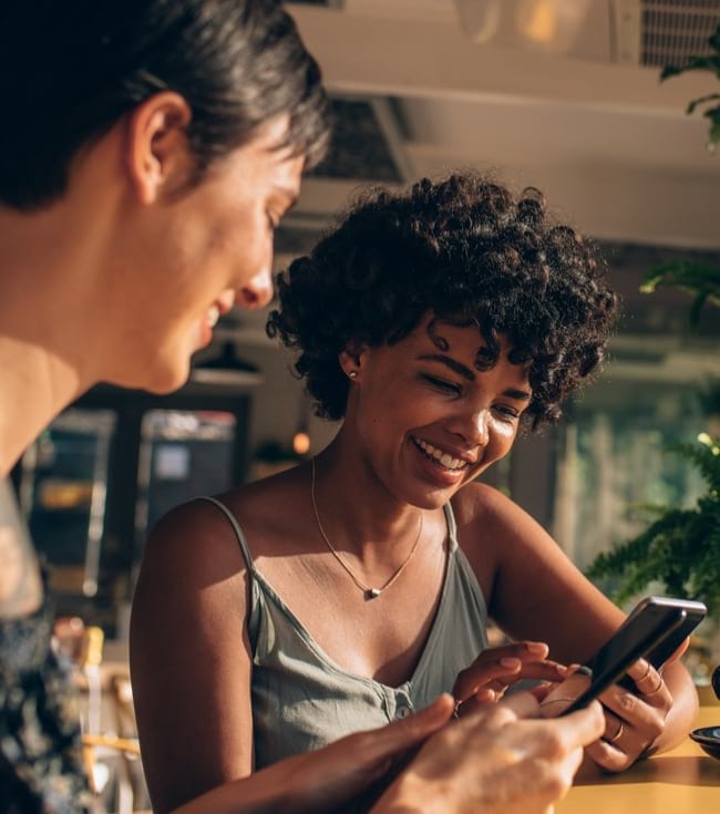 Friends hanging out in a coffee shop on their mobile devices